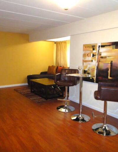 A living room with brown leather furniture and yellow walls.
