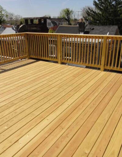 A wooden deck with a railing and railings.