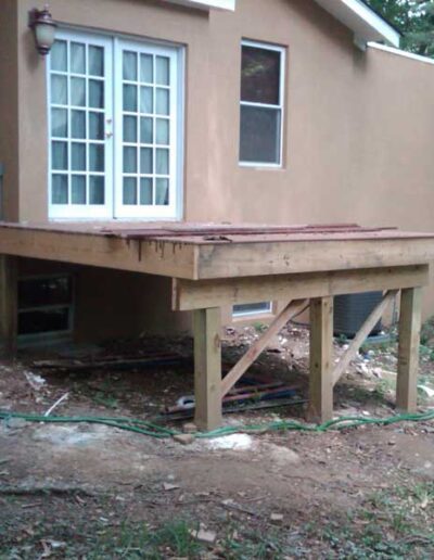 A wooden deck is being built in front of a house.