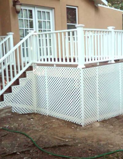 A deck with a white railing and steps.