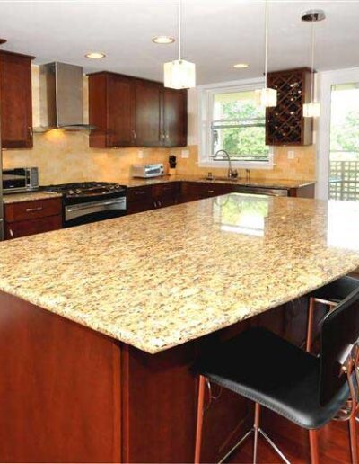 A kitchen with a granite counter top and stainless steel appliances.