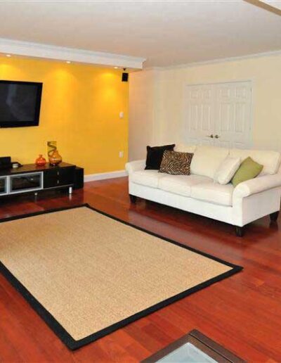 A living room with yellow walls and a tv.