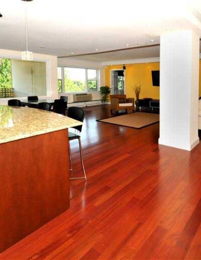 A living room with hardwood floors and a kitchen.
