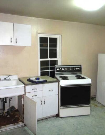 An empty kitchen with a stove and sink.