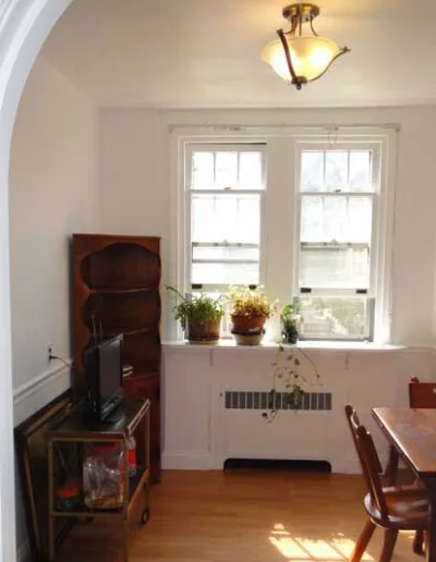An archway leads to a dining room with a table and chairs.